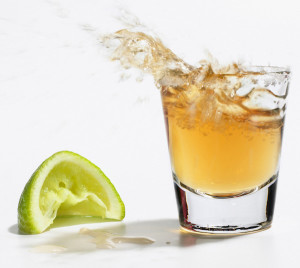 Close up of tequila splashing out of glass
